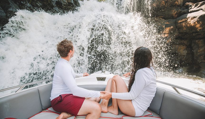Un couple sur un bateau devant une cascade, île Maurice